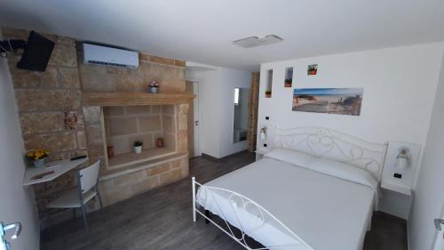 乌真托La Corte dei Marchesi的卧室配有白色的床和壁炉