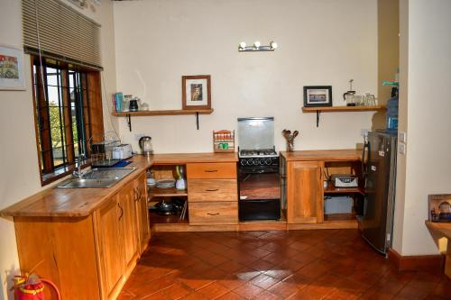 金贾Buyala Bliss on the Nile的厨房配有木制橱柜和冰箱。