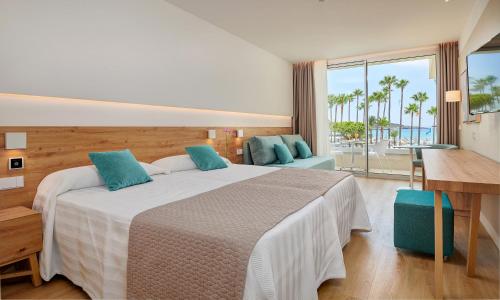 萨科马地中海俱乐部时尚酒店的一间带大床的卧室,享有海景