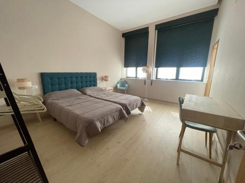 维拉弗兰卡·德尔·比尔Viña Femita的一间卧室配有一张带蓝色床头板的床和两个窗户