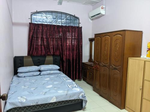 Kampong KelemakAryani Homestay的一间卧室配有一张床、一个梳妆台和一扇窗户。