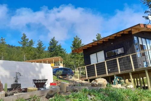 维丘肯Tinyhouse Boyeruca Lodge. Maravillosas vistas de Bosque, Mar y Cielo的一座正在建造的房屋,前面有一辆汽车