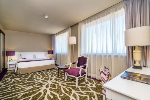 加亚新城波尔图盖亚假日酒店的配有一张床和一把椅子的酒店客房