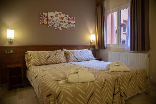 BotHotel & Spa Can Josep的一间卧室配有一张床,上面有两条毛巾