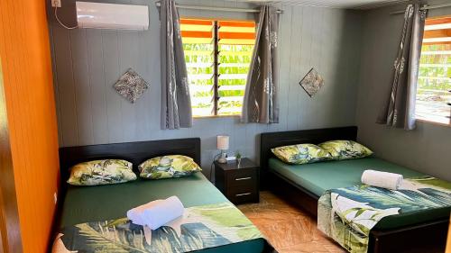提克豪Hiti Tikehau, the ocean side bungalow的带两张床和两个窗户的房间