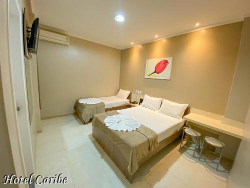 波多韦柳卡里布酒店的酒店客房设有两张床和一张桌子。
