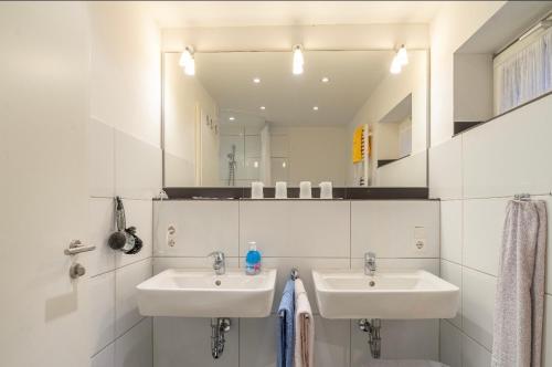 诺德奈Haus Kleemann的一间带两个盥洗盆和大镜子的浴室