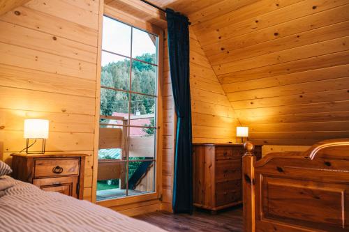 乌斯特龙Chabrowa Chatka的小木屋内一间卧室,设有大窗户