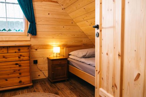 乌斯特龙Chabrowa Chatka的小木屋内一间卧室,配有一张床