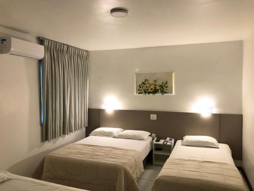 法罗皮利亚Hotel Concatto的酒店客房设有两张床和窗户。