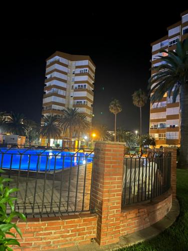 阿尔加罗沃Bonito Apartamento en Algarrobo-Costa的栅栏前有蓝色灯光的建筑