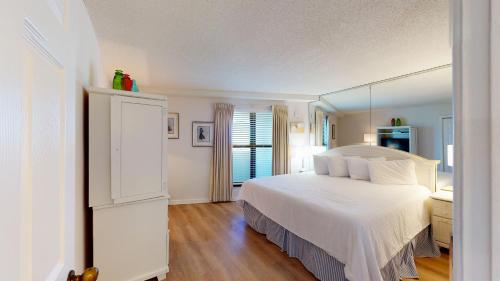 德斯坦Beachside II 4297的卧室配有白色的床和镜子