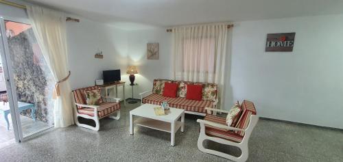 EchedoAPARTAMENTO LOS CACTUS的客厅配有沙发、椅子和桌子