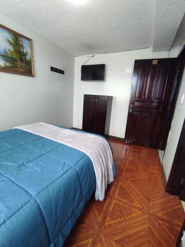 伊瓦拉Hostal Buenaventura Ibarra的一间卧室配有一张带蓝色毯子的床