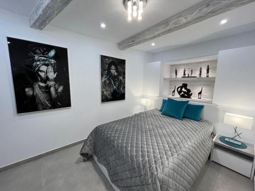 阿德耶Luxury house Atlantico private heated pool的一间卧室配有一张床,墙上挂着一些图片