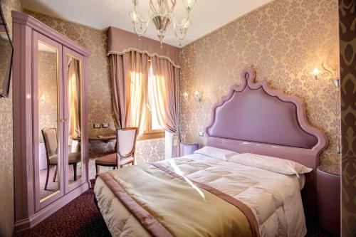 威尼斯多姆斯卡瓦尼斯酒店的一间卧室配有一张大床和镜子