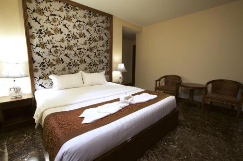 芭堤雅市中心卡特斯里楼酒店的酒店客房,配有带毛巾的床