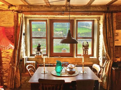 霍姆弗斯The Writers Cottage - Intriguing & Romantic的一间带桌子和窗户的用餐室