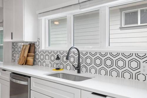 科达伦Gorgeous Downtown Bungalow的白色的厨房设有水槽和窗户