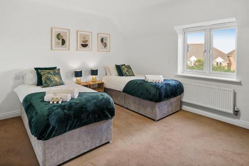 达特福德Townhouse in Dartford sleeps 8 with free parking的一间卧室设有两张床和窗户。