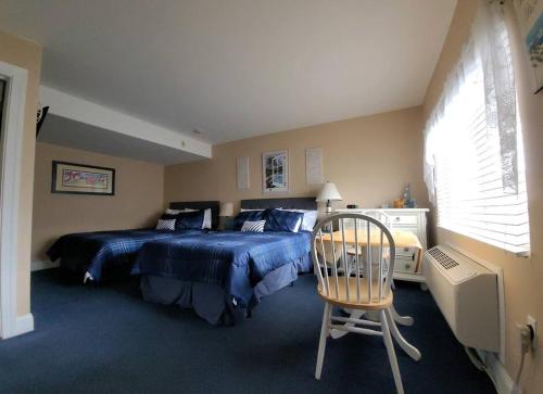 大洋城Sunbeach Condo 900 Wesley Avenue Unit 109的一间卧室配有蓝色的床和椅子