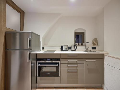 罗滕堡霍夫布鲁嫩公寓的厨房配有不锈钢冰箱和水槽