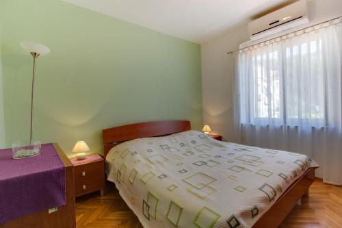 木洛希尼Apartments by the sea Mali Losinj (Losinj) - 15576的一间卧室配有一张床、一张桌子和一个窗户。