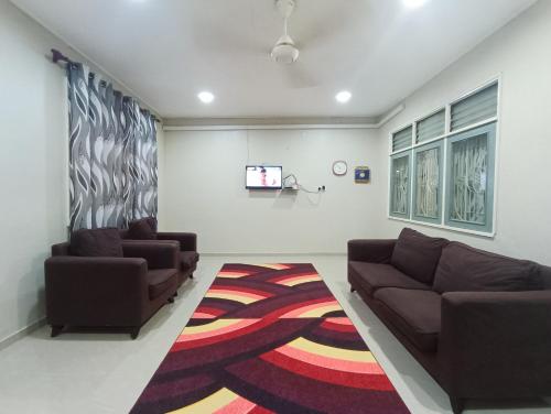 Kuala BerangHomestay Sejati的客厅配有两张沙发和一台电视机