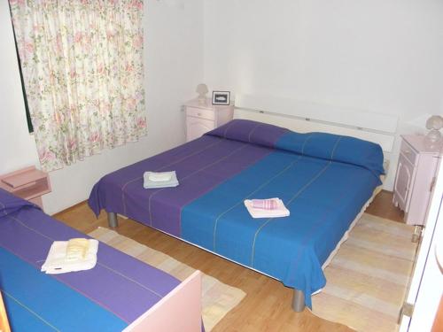 布拉托Apartments by the sea Crnja Luka, Korcula - 15978的一间卧室配有一张带蓝色床单的床和一张桌子。