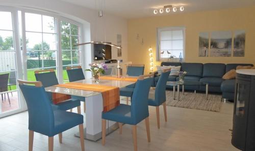 特希尔An den Zwillingsmühlen的一间带桌子和蓝色椅子的用餐室