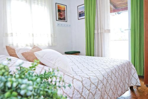 萨利Seaside holiday house Sali, Dugi otok - 16128的一间卧室配有一张带绿色窗帘的床
