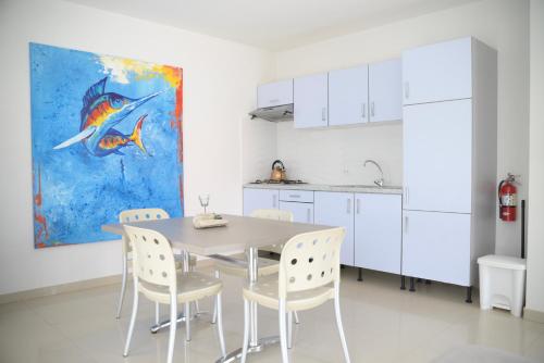 努尔德Beach Homes Aruba的厨房配有桌椅和绘画作品