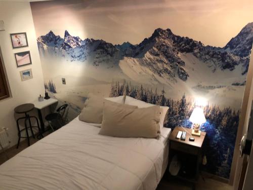 Lo BarnecheaDepartamento residencial Valle Nevado的卧室配有一张挂有山壁画的床。