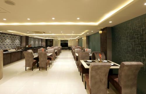 古尔冈Hotel Sakura by Maps的一间带桌椅的餐厅和一间酒吧
