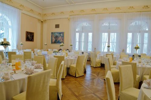 OstromeckoZespół Pałacowo-Parkowy w Ostromecku的一间设有桌椅和白色桌布的房间