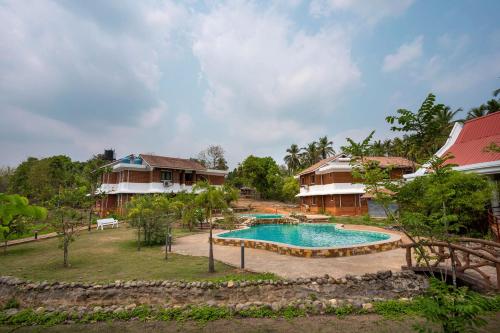 SawantwadiSarth Ayurveda Retreat and Wellness Centre的享有带游泳池的度假村的空中景致