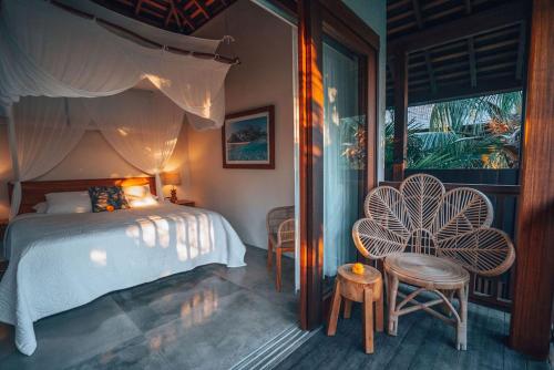 乌鲁瓦图梅拉利滨宁旅馆的一间卧室配有一张床、两把椅子和一个窗户