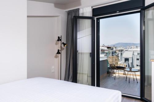 沃洛斯Empress Luxury Residences的一间卧室设有一张床,享有阳台的景色