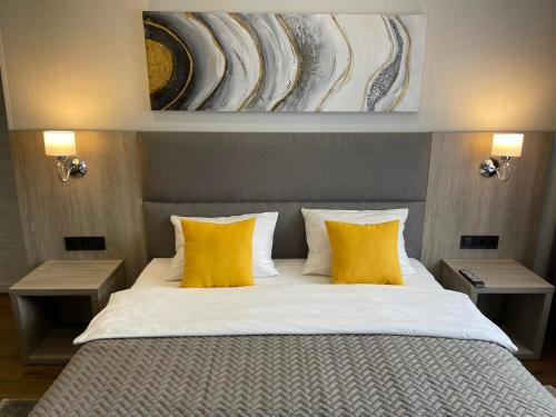 卢茨克乌克兰大厦酒店的一间卧室配有一张带两个黄色枕头的床