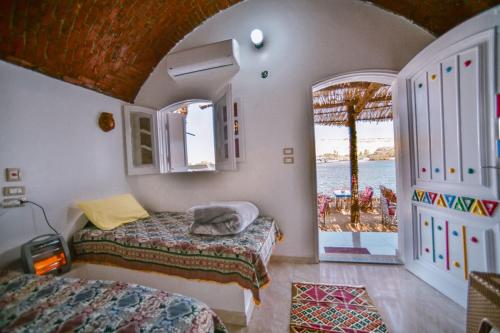 阿斯旺Kafana Guest House Nile View的一间带两张床的卧室,享有海景