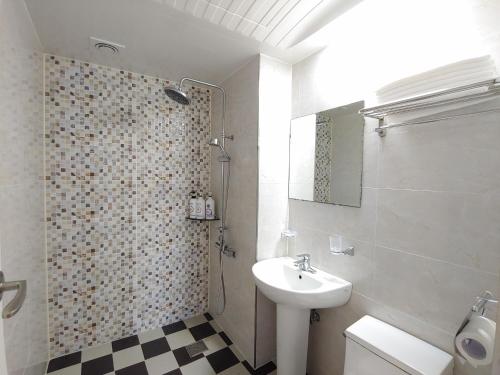 西归浦市Fellisia Hotel的一间带水槽、卫生间和淋浴的浴室