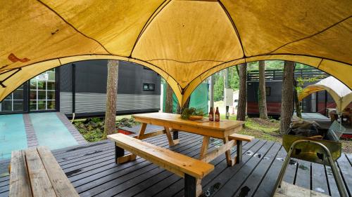 富士河口湖森と湖の楽園ＷorkshopＣampＲesort的木甲板,配有桌子和帐篷