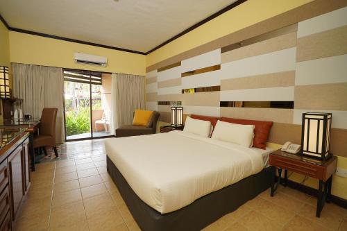 珍拉丁珍拉汀海滩度假村别墅酒店的一间带大床的卧室和一间客厅