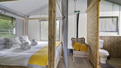 赫特福德Finest Retreats - The Herdwick Safari Tent的一间卧室配有一张床和一个卫生间