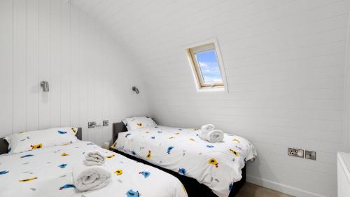 赫特福德Finest Retreats - The Chicken Coop的配有2张床的白色墙壁和窗户。