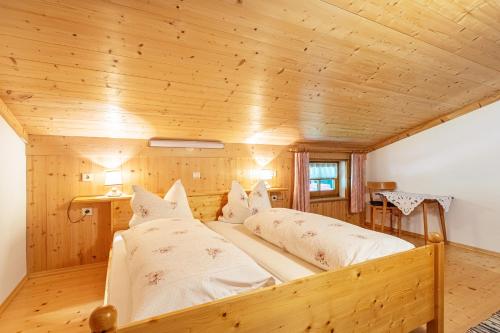 洛弗附近圣马丁Ferienwohnung Jägermeister的配有木天花板的客房内的两张床