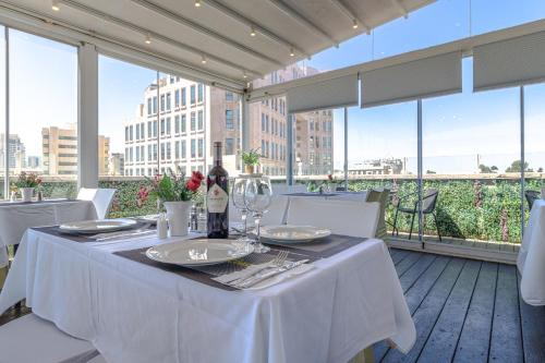 耶路撒冷阿格里帕精品酒店的阳台上的白色桌子和一瓶葡萄酒