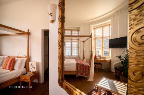 哥本哈根巴贝特古尔德斯梅登酒店的卧室两张照片,配有一张床和镜子