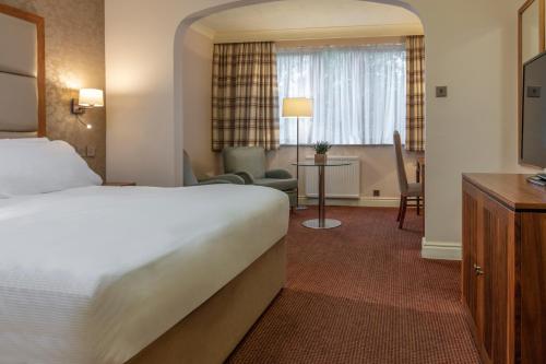 埃文河畔斯特拉特福Stratford Manor Hotel的酒店客房设有床和客厅。