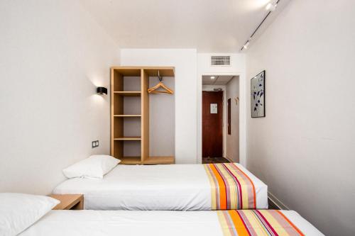 佩皮尼昂Hôtel PB - Paris-Barcelone的白色墙壁客房的两张床